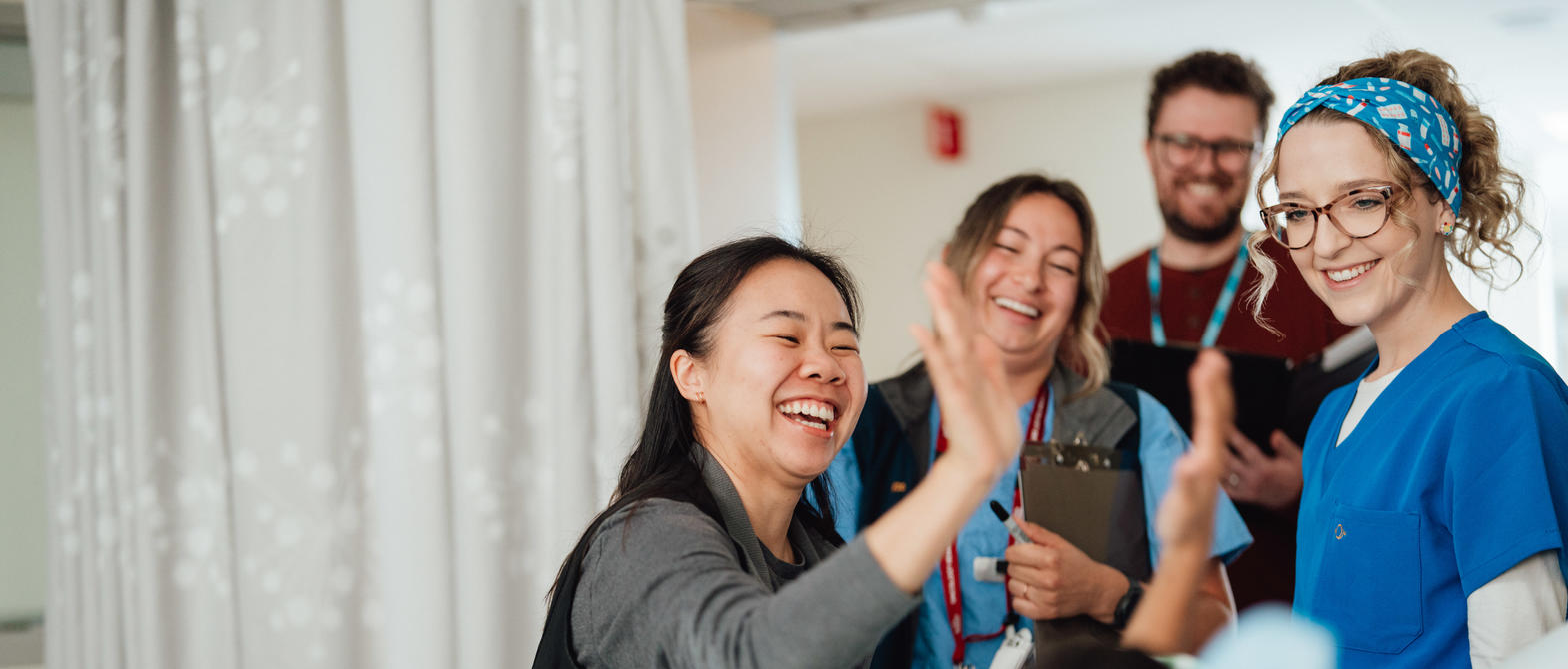 A nurse giving a high-five to a young patient