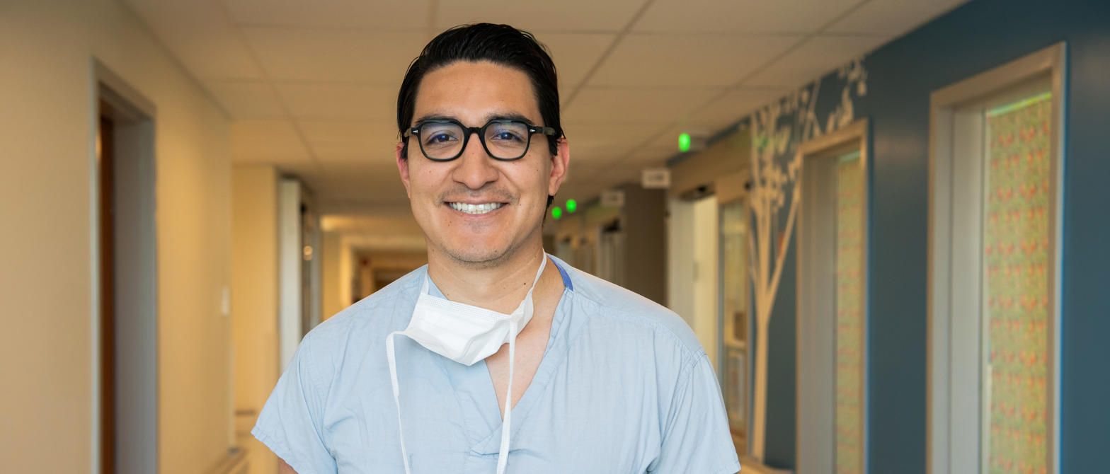 A doctor smiling for a photo in the hallway of BC Children's Hospital