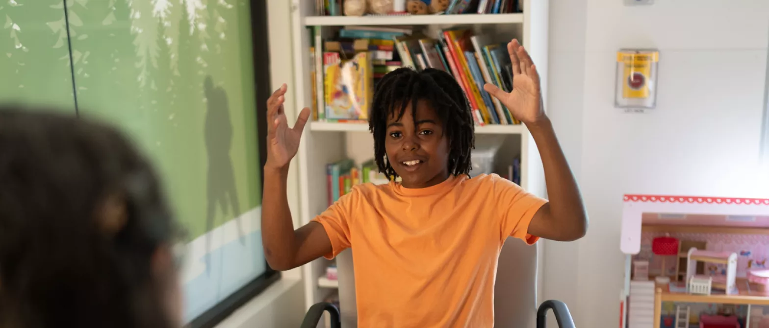 Child working with psychologist, seated sharing a story.