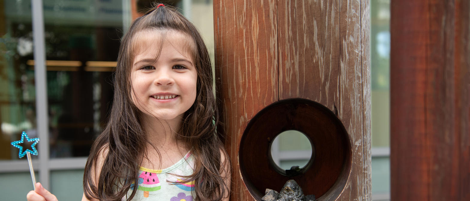 Smiling girl with wand playing outside