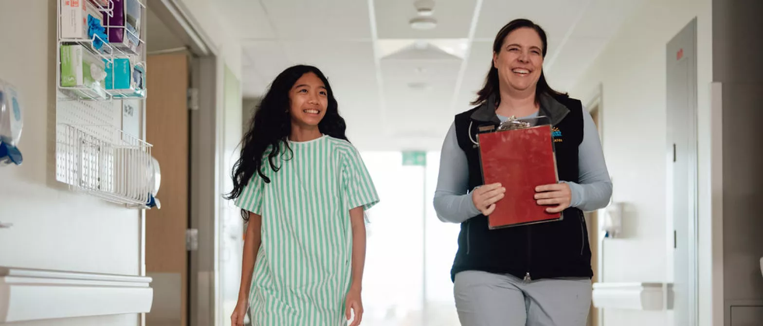 Nursing walking down the hallway with a young patient