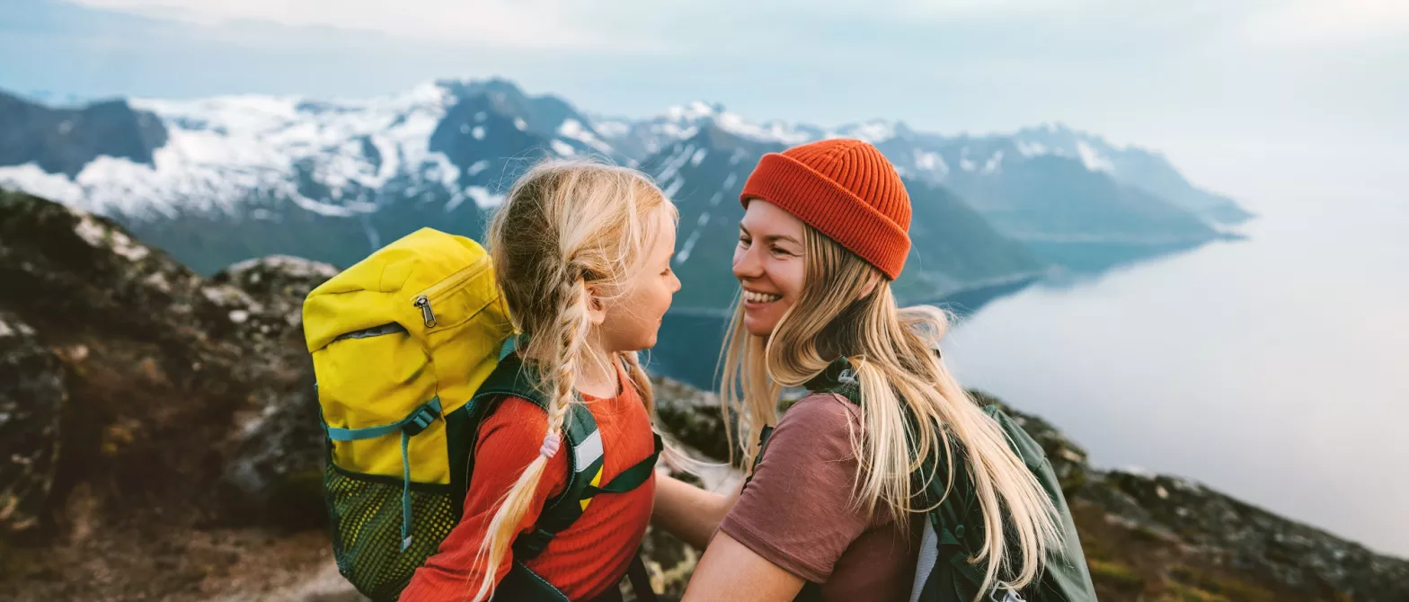 Child and woman embracing on beautiful mountaintop