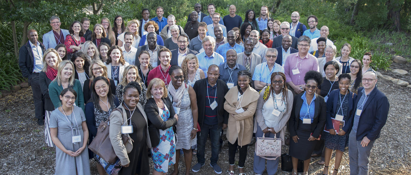 A group of researchers and health professionals post for a group photo outside