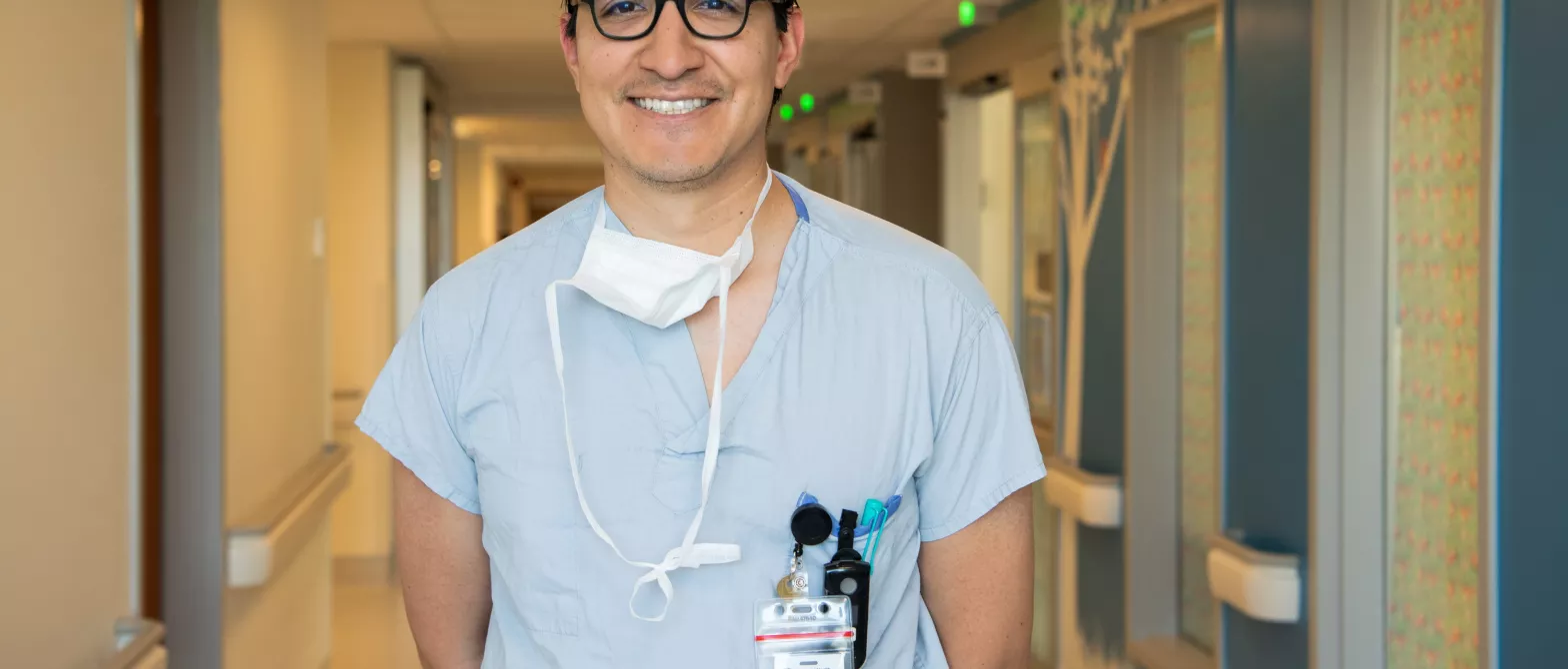 A doctor smiling for a photo in the hallway of BC Children's Hospital