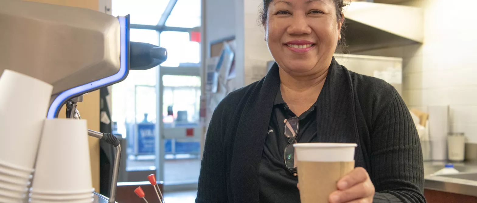 A barista hands the viewer a coffee at the cafe in BC Children's Hospital