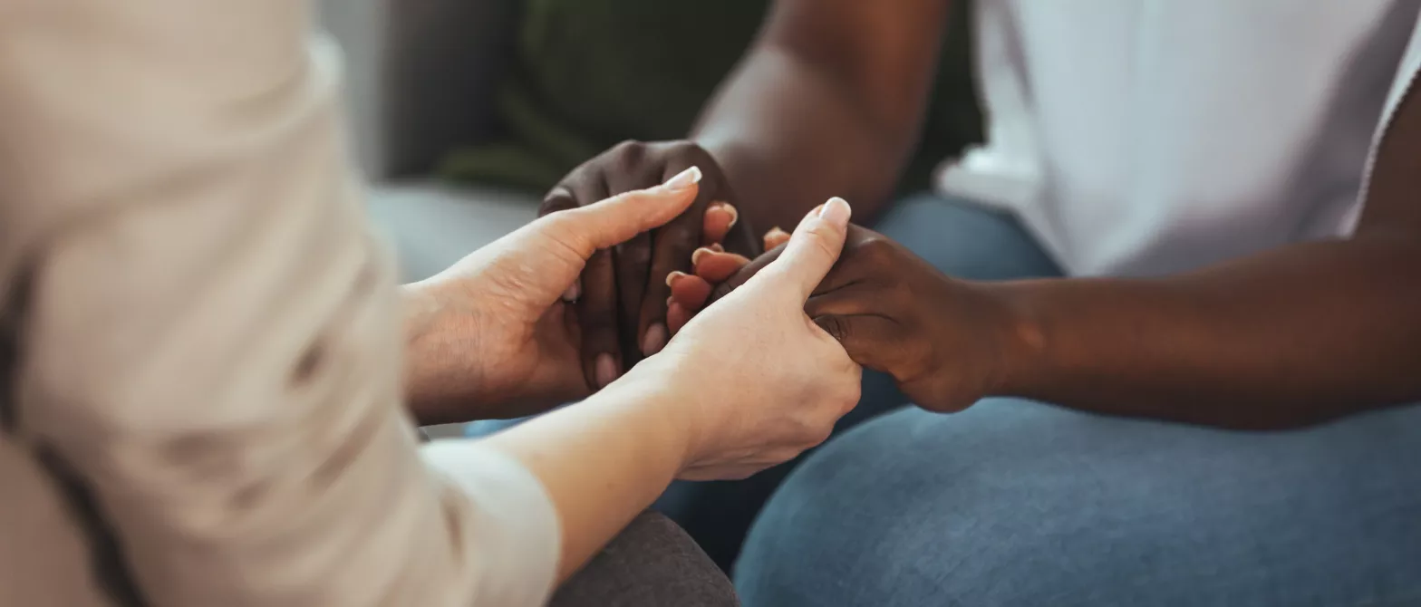 Seated people holding each other's hands