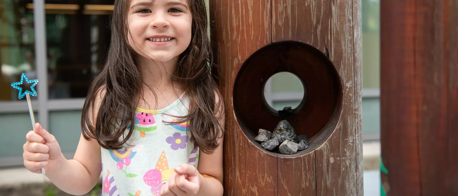 Smiling girl with wand playing outside