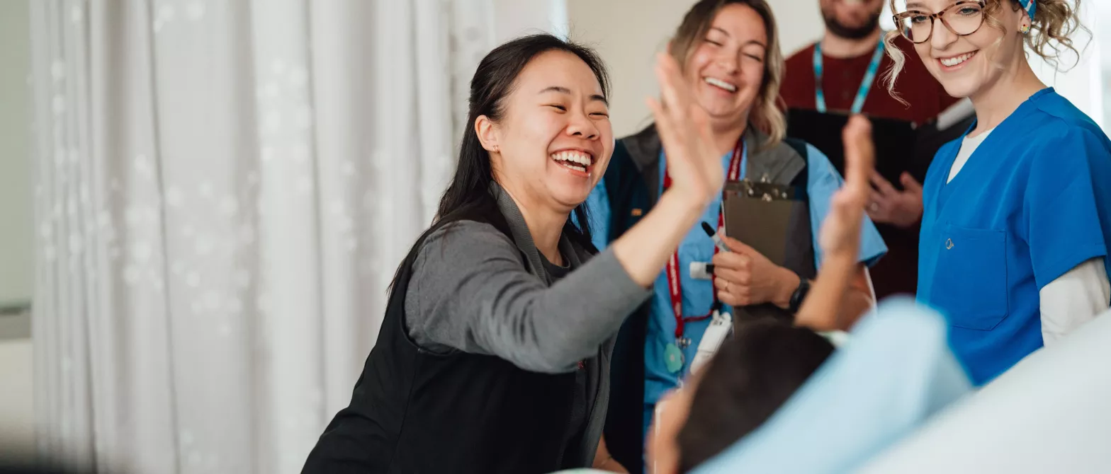 A nurse giving a high-five to a young patient