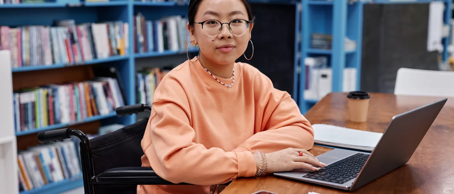 A youth working on a laptop in a library