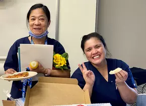 Two BCCH staff members posing with flowers and cupcakes