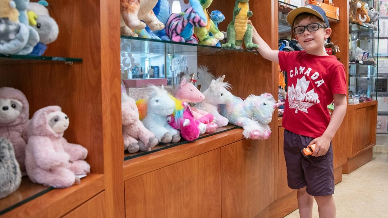 Happy boy holding toy in gift shop