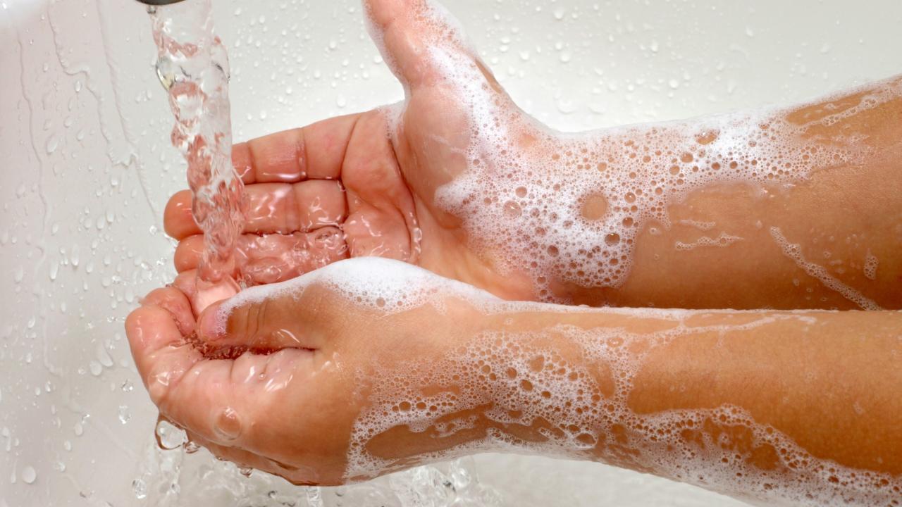 Soapy hands under running water