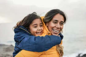 A parent and child laughing while on a hike