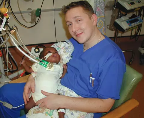 Young David Waller holding a baby