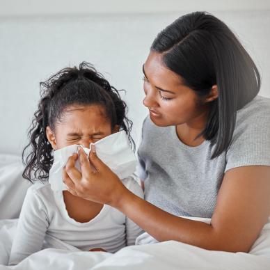 Mother helping child blow nose