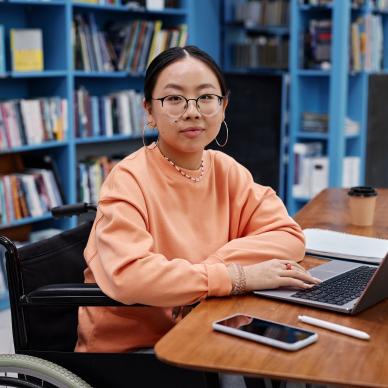 A youth working on a laptop in a library